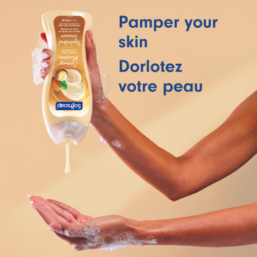 A person pours the creamy, beige-colored shower gel from the bottle into their palm. The text, in English and French, reads: "Pamper your skin."