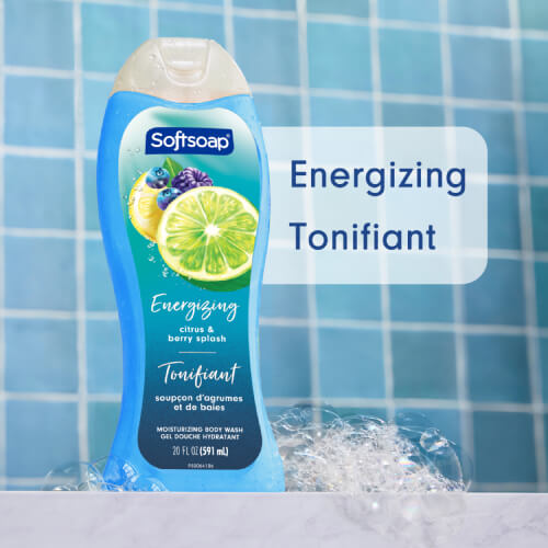 Softsoap Energizing Citrus and Berry Splash body wash bottle in a blue tiled shower setting with soap bubbles. Text overlay reads "Energizing" and "Tonifiant."