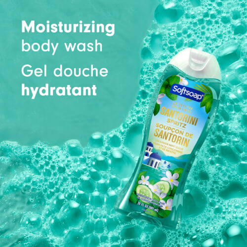 The Softsoap Santorini Spritz bottle rests on a bed of teal-colored water bubbles. Text on the left highlights the phrases "Moisturizing body wash" and "Gel douche hydratant."