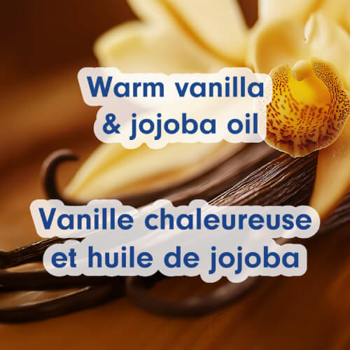 A macro close-up of a yellow orchid flower and dark vanilla beans. Text overlays read "Warm vanilla & jojoba oil" and "Vanille chaleureuse et huile de jojoba."